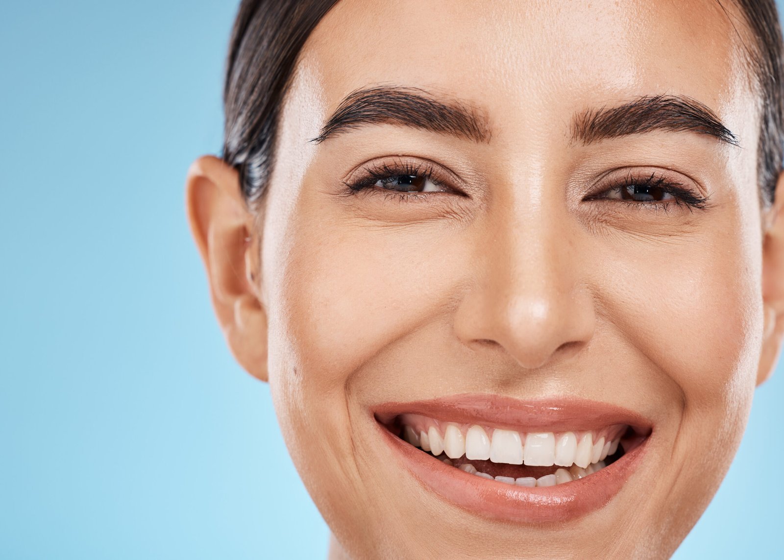 Portrait, face and skincare with a model woman in studio on a blue background for natural treatment.